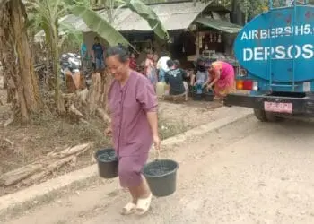 AMBIL AIR BERSIH–Seorang ibu warga Desa Mekarjaya, Kecamatan Mekarjaya, Kabupaten Pandeglang, mengambil air bersih dari tangki yang disalurkan oleh relawan kemanusiaan, Sabtu (9/9/2023). (ISTIMEWA)