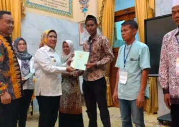 Bupati Serang Ratu Tatu Chasanah, secara simbolis menyerahkan sertifikat kepada warga, Rabu (27/12/2023). (SIDIK/SATELITNEWS.COM)