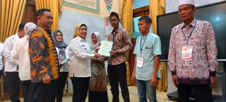 Bupati Serang Ratu Tatu Chasanah, secara simbolis menyerahkan sertifikat kepada warga, Rabu (27/12/2023). (SIDIK/SATELITNEWS.COM)