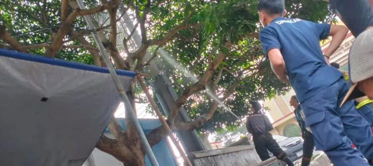 Petugas BPBDPK Kabupaten Pandeglang, sedang memadamkan api yang berkobar akibat korsleting listrik dari tiangnya, Senin (12/2/2024). (ADIB FAHRIE/SATELITNEWS.COM)