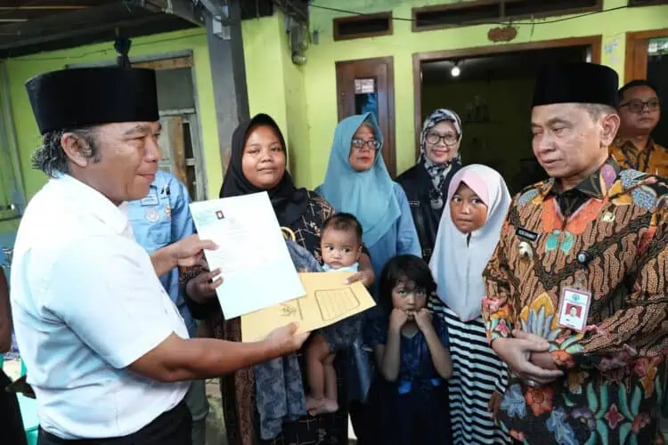 Pj Gubernur Banten Al Muktabar, santuni keluarga petugas KPPS yang meninggal dunia. (ISTIMEWA)