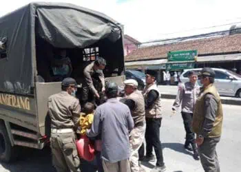 TERJARING RAZIA: Petugas Satpol PP dan Dinsos Kabupaten Tangerang bersama anggota Polresta Tangerang, sedang mengangkut salah satu PMKS ke mobil di Jalan Raya Serang, Desa Cikupa, Kecamatan Cikupa, Selasa (5/3). (ALFIAN HERIANTO)