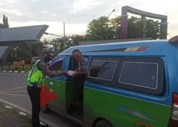 MEMBERIKAN TAKJIL: Seorang anggota Polresta Tangerang Polda Banten saat membagikan takjil kepada pengendara atau pejalan kaki. (ISTIMEWA)