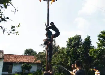 Para peserta panjat pinang, sedang berusaha bahu membahu untuk meraih ujung (hadiah).(MARDIANA/SATELITNEWS.COM)