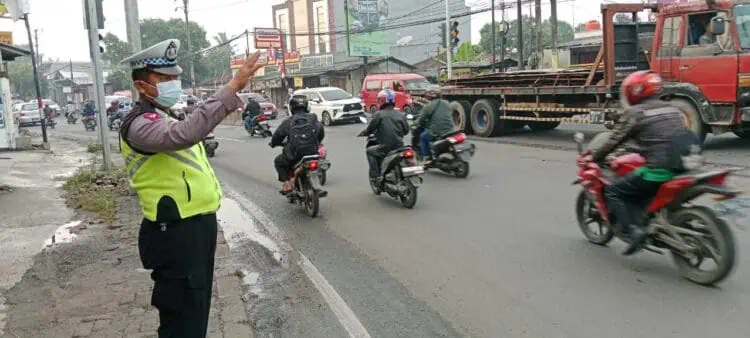 ATUR LALU LINTAS: Seorang anggota Polisi sedang mengatur arus lalu lintas (Lalin) di Jalan Raya Serang, Desa Cibadak, Kecamatan Cikupa. (DOK/SATELIT NEWS)
