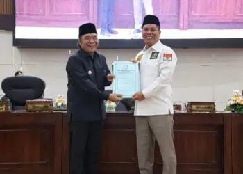 PJ Gubernur Banten Al Muktabar menerima dokumen pandangan umum fraksi dari Wakil Ketua DPRD Banten Fahmi Hakim, atas nota pengantar Gubernur mengenai Rancangan Peraturan Daerah (Raperda) tentang Pertanggungjawaban Pelaksanaan Anggaran Pendapatan dan Belanja Daerah (APBD) Tahun Anggaran 2023. (LUTHFI/SATELITNEWS.COM)