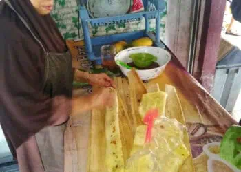 Ibu Jum'iah, sedang membuat kue Balok Menes, di warungnya. (MARDIANA/SATELITNEWS.COM)