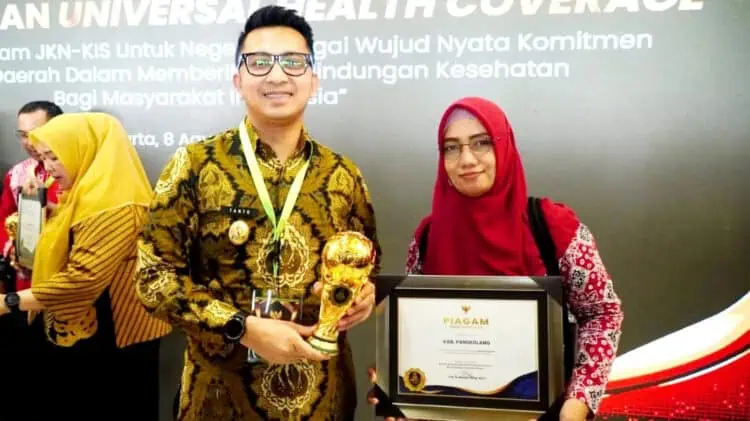 Wabup Pandeglang, Tanto Warsono Arban, menunjukkan penghargaan dari BPJS Kesehatan. (ISTIMEWA)