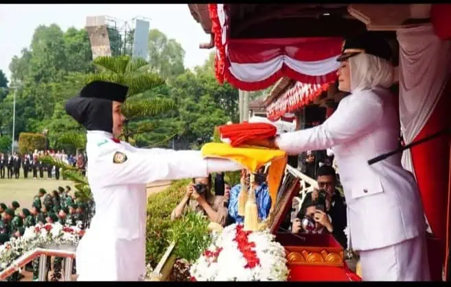 Bupati Pandeglang Irna Narulita (kanan), berikan duplikat Bendera Pusaka Merah Putih kepada petugas Paskibra, Sabtu (17/8/2024). (ISTIMEWA)