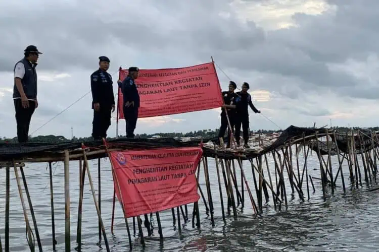 Petugas membentangkan spanduk, di pagar Laut di Kabupaten Tangerang, beberapa waktu lalu. (DOKUMEN/SATELITNEWS.COM)