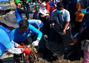 Puluhan masyarakat dan aparatur pemerintahan desa dan kecamatan, membersihkan sampah di kawasan Teluk, Kecamatan Labuan, Kabupaten Pandeglang, Minggu (9/2/2025). (ISTIMEWA)