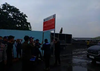 Petugas KLH memasang papan peringatan penyegelan di TPA Jatiwaringin. (ALFIAN/SATELITNEWS)