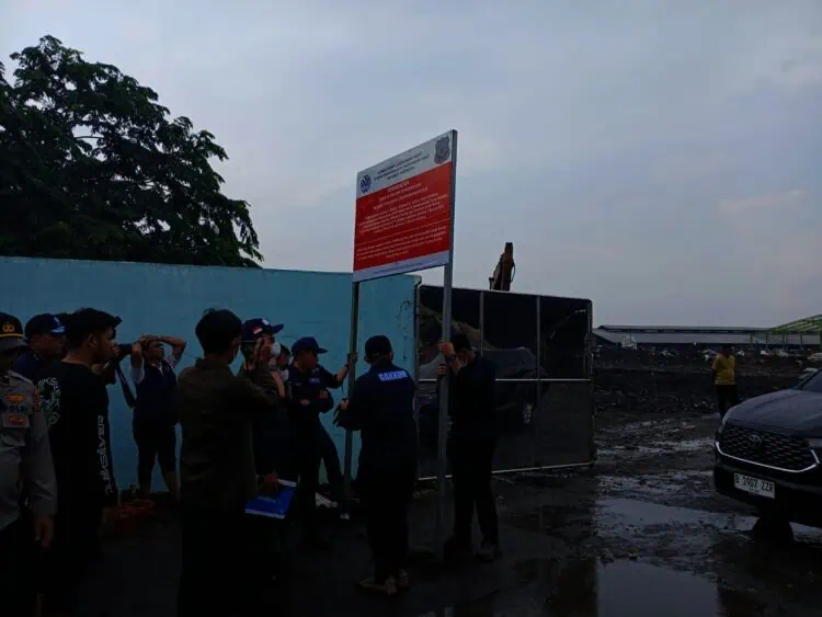 Petugas KLH memasang papan peringatan penyegelan di TPA Jatiwaringin. (ALFIAN/SATELITNEWS)