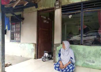 Seorang lansia di Kampung Karet, Desa Teluk, Kecamatan Labuan duduk diteras rumahnya. (ISTIMEWA)