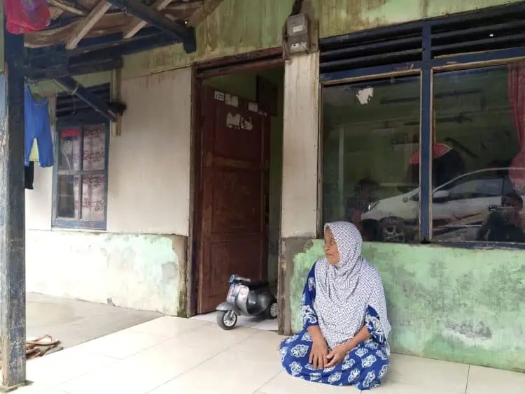 Seorang lansia di Kampung Karet, Desa Teluk, Kecamatan Labuan duduk diteras rumahnya. (ISTIMEWA)