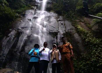 Gubernur Banten Andra Soni, Bupati Pandeglang Raden Dewi Setiani, bersama aparatur Kecamatan Carita, berfoto bersama dengan latar belakang Curug Cimanggung, Desa Cinoyong, Kecamatan Carita, Kabupaten Pandeglang, Selasa (2/12/2025). (ISTIMEWA)