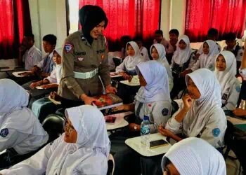 MEMBERIKAN BUKU : Personel Polres Serang memberikan buku diacara sosialisasi potensi kenakalan remaja. (ADIB FAHRIE/SATELITNEWS.COM)