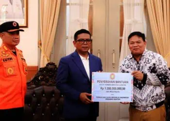 MENYERAHKAN BANTUAN : Ketua PGRI Banten Jamaludin (kanan), menyerahkan bantuan secara simbolis kepada Gubernur Banten Andra Soni. (ISTIMEWA)