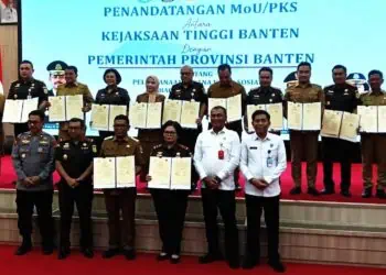 MENUNJUKKAN DOKUMEN : Gubernur Banten Andra Soni (tengah depan) bersama Kajati Banten Bernadeta Maria Elastiyani (depan) didampingi bupati/walikota se Banten dan Kajari se Banten menunjukan dokumen MoU penerapan KUHP baru. (ISTIMEWA)