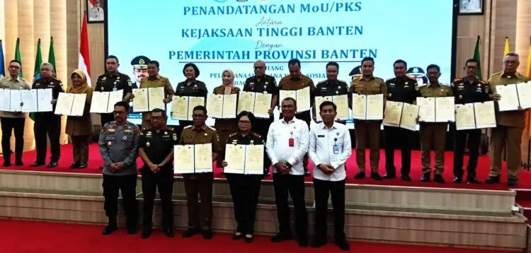 MENUNJUKKAN DOKUMEN : Gubernur Banten Andra Soni (tengah depan) bersama Kajati Banten Bernadeta Maria Elastiyani (depan) didampingi bupati/walikota se Banten dan Kajari se Banten menunjukan dokumen MoU penerapan KUHP baru. (ISTIMEWA)