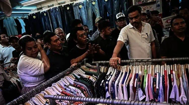 Menteri UMKM Maman Abdurrahman (kedua kanan) dan Wakil Ketua Badan Aspirasi Masyarakat DPR RI Adian Napitupulu (ketiga kiri) berbincang dengan pedagang, di area perdagangan pakaian bekas impor (thrifting) di Pasar Senen, Jakarta, Minggu (30/11/2025). (ISTIMEWA)