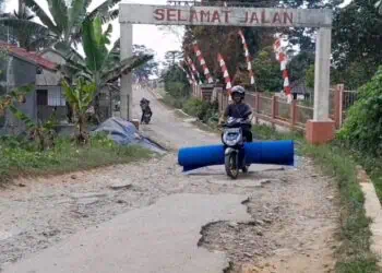 RUSAK PARAH : Seorang pengendara melintas di Ruas jalan Cicadas-Pasirpeuteuy-Kaduengan, Kabupaten Pandeglang yang kondisinya rusak parah. (ISTIMEWA)