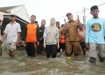 Bupati Serang Ratu Rahmatuzakiyah, terjang banjir di Perumahan Bumi Ciruas Permai (BCP) 2, Desa Ranjeng, Kecamatan Ciruas, Kabupaten Serang, Selasa (13/1/2026) sore. (SIDIK/SATELITNEWS.COM)