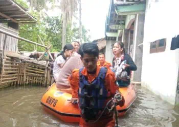 Petugas BPBD Kabupaten Serang, tengah mengevakuasi masyarakat saat banjir melanda wilayah Binuang, Kabupaten Serang, belum lama ini. (ISTIMEWA)