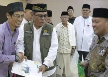 MENYERAHKAN BANTUAN : Wakil Ketua II Baznas Banten Pery Hasanudin (dua dari kiri) menyerahkan bantuan bedah rumah. (ISTIMEWA)