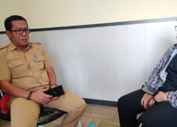 Kepala Bidang (Kabid) UMKM Diskoumperindag Kabupaten Serang, Yosi Ekamarsa, saat berbincang dengan warga di kantornya. (ISTIMEWA)