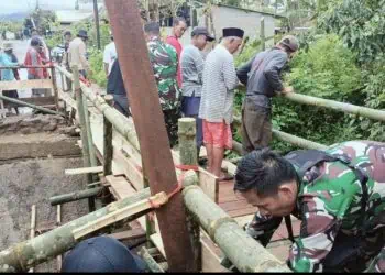 BANGUN JEMBATAN SEMENTARA - Untuk mendukung kelancaran akses masyarakat, anggota TNI Koramil 0105/Mandalawangi Kodim 0601/Pandeglang, turun tangan membangun jembatan sementara penghubung Desa Sinarjaya - Panjangjaya, Kecamatan Mandalawangi, Kabupaten Pandeglang, Rabu (4/2/2026). (ISTIMEWA)