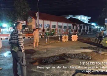 PERBAIKAN JALAN - Tim dari DPUPR Kabupaten Pandeglang, memperbaiki jalan rusak dan berlubang di simpang Alun-alun Pandeglang, tepatnya di samping Kantor BPKAD setempat, Rabu (22/4/2026) malam. (ISTIMEWA)