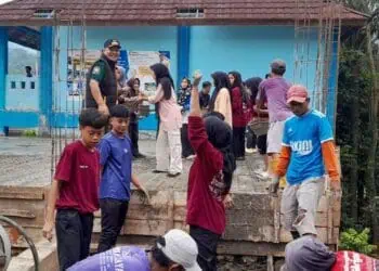 BERGOTONG ROYONG - Camat Pulosari Juhanes Waluyo, bersama para pelajar dan masyarakat, bergotong royong mengecor bangunan sekolah. (ISTIMEWA)