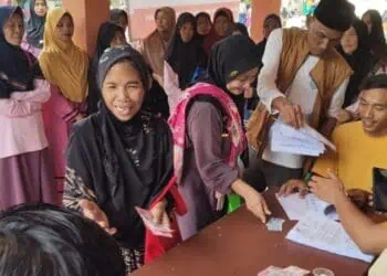 MENCAIRKAN BANSOS : Sejumlah KPM, mencairkan Bansos dari pemerintah, beberapa waktu lalu.(DOKUMEN/SATELITNEWS.COM)