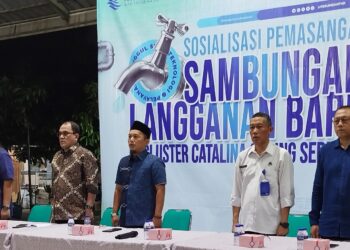 Direktur Utama Perumda TKR Sofyan Safar (kedua kiri), anggota Komisi II DPRD Kabupaten Tangerang Aditya Wijaya (ketiga kiri),  Direktur Teknik Yadi Treviyadi (kiri),  Direktur Umum Sani Tora Wicaksono (kedua kanan) dan Ketua RW Catalina A Eko Priyono (kanan) menyanyikan lagu kebangsaan Indonesia Raya bersama warga dalam rangkaian acara kegiatan sosialisasi pemasangan sambungan baru di Balai RW Catalina, Jumat (6/6/2026) malam.