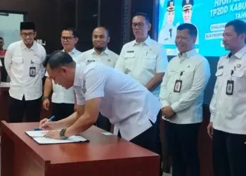PENANDATANGANAN -- Kepala Bapenda Kabupaten Serang Lalu Farhan Nugraha (tengah), melakukan penandatangan komitmen bersama pemanfaatan digitalisasi daerah. (ISTIMEWA)