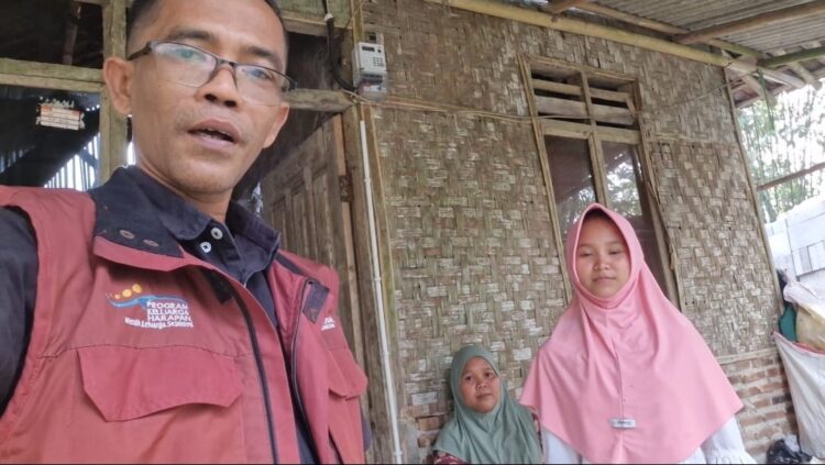 BERKUNJUNG -- Pendamping sosial PKH Kecamatan Cikeusal, Marpindo Desra (kiri), saat berkunjung ke rumah Marni. (ISTIMEWA)
