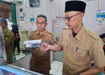 TERA ULANG - Petugas Dinas Koperasi UMKM Perindustrian dan Perdagangan (Diskoumperindag) Kabupaten Serang, melakukan tera ulang timbangan elektronik toko emas yang ada di Pasar Ciruas, Selasa (21/7/2026). (ISTIMEWA)
