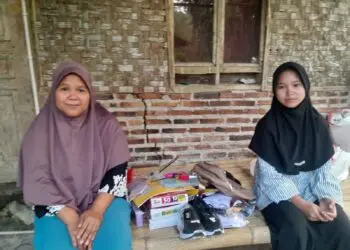 TERIMA BANTUAN - Neng Marni, warga Kampung Seba, Desa Harundang, Kecamatan Cikeusal, Kabupaten Serang, menerima bantuan peralatan sekolah dan alat transportasi, agar bisa kembali bersekolah. (ISTIMEWA)