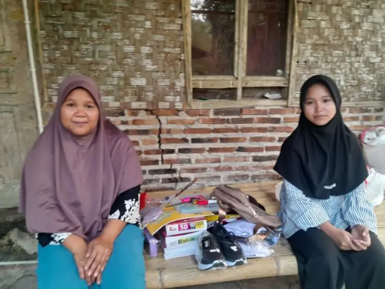 TERIMA BANTUAN - Neng Marni, warga Kampung Seba, Desa Harundang, Kecamatan Cikeusal, Kabupaten Serang, menerima bantuan peralatan sekolah dan alat transportasi, agar bisa kembali bersekolah. (ISTIMEWA)