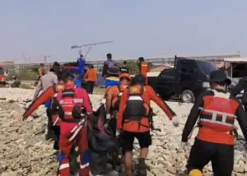 MEMBAWA JENAZAH: Tim gabungan, membawa jenazah korban terbawa arus di pantai di Kecamatan Citangkil, Kota Cilegon. (ISTIMEWA)