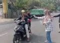 BAGIKAN MASKER - Tim Nakes dan pegawai Puskesmas Labuan bersama relawan, membagikan masker kepada pengendara yang melintas, Minggu (6/9/2026). (ISTIMEWA)
