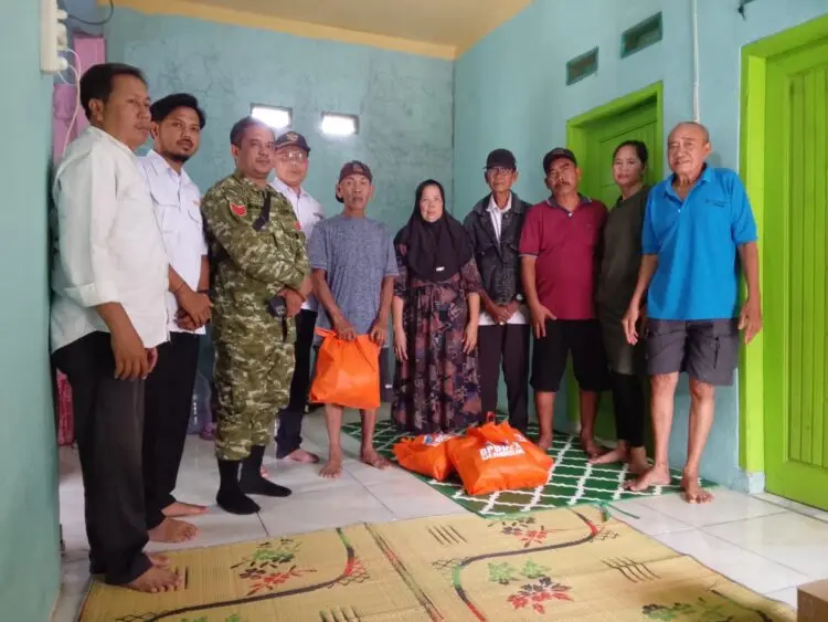BERI BANTUAN -- Babinsa Koramil 0104/Cimanuk Kodim 0601/Pandeglang, turut mendampingi Pemerintah Desa Kadumadang untuk menyalurkan bantuan kepada warga yang menjadi korban kebakaran. (ISTIMEWA)