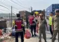 BERSIHKAN SAMPAH -- Petugas Polisi dari Polsek Cikande Polres Serang, bersama personel Dinas Kebersihan dan Pemerintah Kecamatan (Pemkec) Cikande, membersihkan tumpukan sampah liar di tepi Jalan Raya Serang-Jakarta, Desa Parigi, Kecamatan Cikande, Selasa (15/9/2026). (ISTIMEWA)
