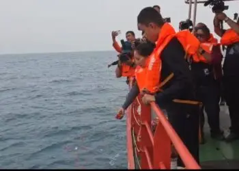TABUR BUNGA : Salah satu keluarga jurnalis yang hilang di perairan Selat Sunda, melakukan tabur bunga. (ISTIMEWA)