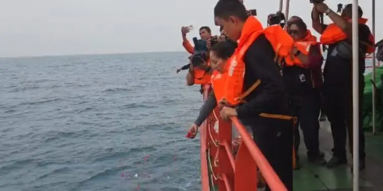 TABUR BUNGA : Salah satu keluarga jurnalis yang hilang di perairan Selat Sunda, melakukan tabur bunga. (ISTIMEWA)