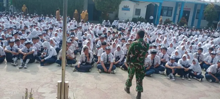PENYAMPAIAN MATERI -- Danramil 0101/Pandeglang Kapten Inf Dedi Bonar Sirait, menyampaikan materi wawasan kebangsaan dihadapan ratusan pelajar SMPN 1 Pandeglang, Senin (28/9/2026). (ISTIMEWA)