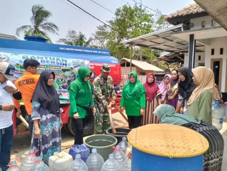SALURKAN BANTUAN AIR BERSIH -- Personel Koramil 0116/Cikeusik Kodim 0601/Pandeglang bersama Persit Kartika Chandra Kirana (KCK) Ranting 17 Cikeusik Cabang XXXIII Dim 0601/Pandeglang, menyalurkan bantuan air bersih kepada masyarakat di Kecamatan Cikeusik, Kabupaten Pandeglang, Senin (12/10/2026). (ISTIMEWA)