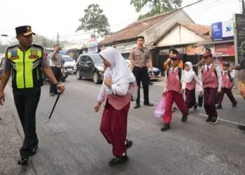 MENYEBRANGKAN ANAK SEKOLAH : Kapolda Banten Irjenpol Hendra Kurniawan, menyebrangkan anak sekolah dalam kegiatan Gatur pagi di SDN Banjarsari 2. (ISTIMEWA)