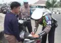 MEMBERIKAN TEGURAN : Personel Polisi Satuan Lalu Lintas Polda Banten, memberikan teguran berupa tilang kepada pengendara motor, karena tidak menggunakan helm. (ISTIMEWA)
